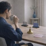 医療脱毛を急がず、自分のタイミングで判断する40代男性が、天秤を前にコーヒーを飲みながら落ち着いて考えている様子