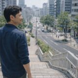 階段を登りきり街を見下ろす40代男性のイメージ（VIO脱毛の変化を理解した状態）