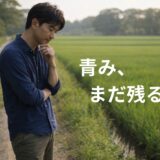 田んぼ道を歩く途中で立ち止まり、顎に手を当てて少し考える40代男性の様子