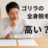 机の上に2枚の見積書を広げ、全身脱毛の料金を比較している40代男性
