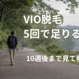 緑の並木道を前に向かって歩く40代日本人男性の後ろ姿